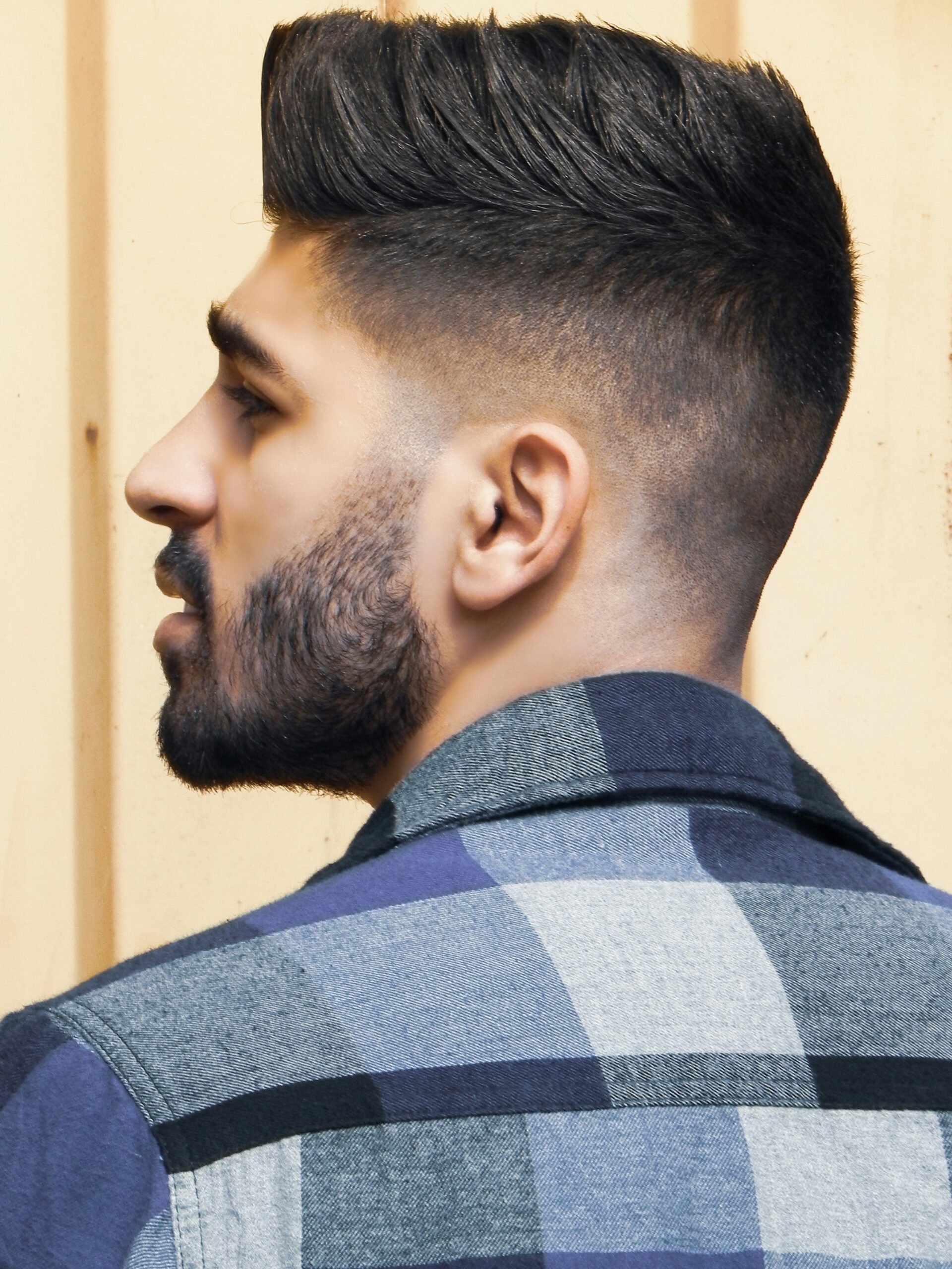 Portrait de profil d'un homme avec une coiffure faux hawk associée à un taper fade haut